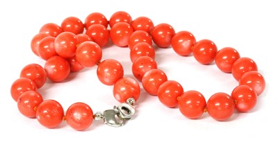 Lot 214 - A single row uniform dyed coral bead necklace
