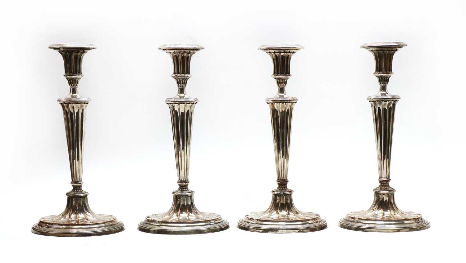 Lot 11 - A set of four George III Sheffield Plated candlesticks of Adam design