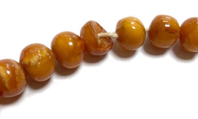 Lot 27 - A single row slightly graduated butterscotch amber prayer bead necklace