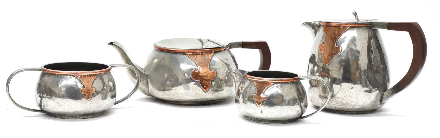 Lot 45 - An Arts and Crafts pewter and copper mounted four-piece tea set