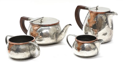 Lot 45 - An Arts and Crafts pewter and copper mounted four-piece tea set