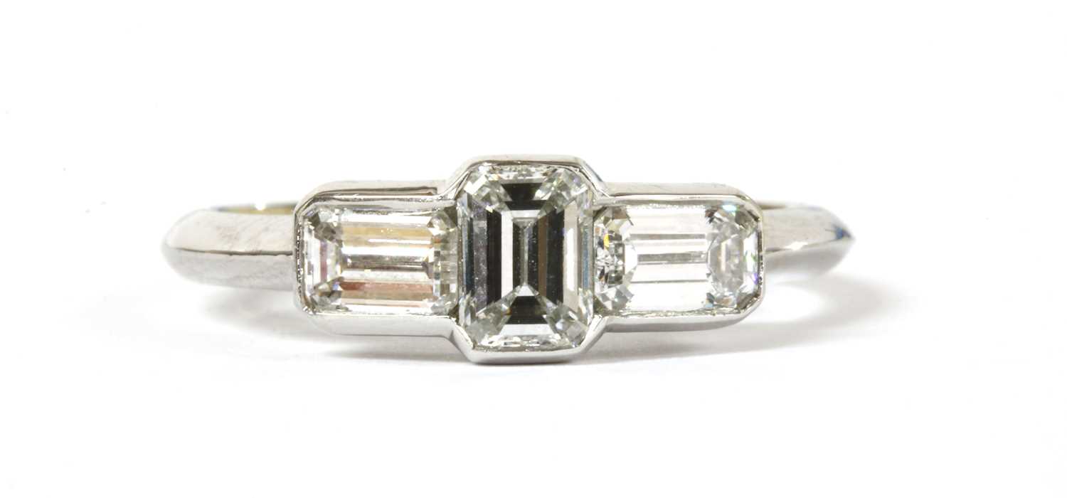 Lot 113 - A platinum three stone emerald cut diamond ring