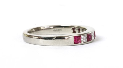 Lot 138 - A platinum ruby and diamond half eternity ring