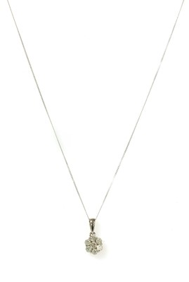 Lot 124 - A white gold diamond daisy cluster pendant