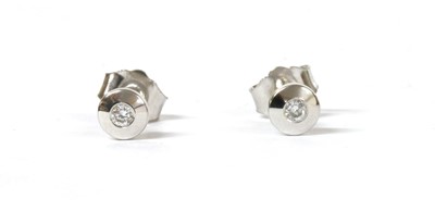 Lot 110 - A pair of white gold single stone diamond stud earrings