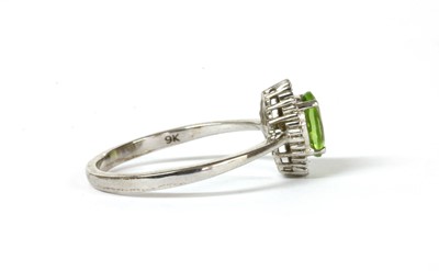 Lot 194 - A white gold peridot and diamond cluster ring