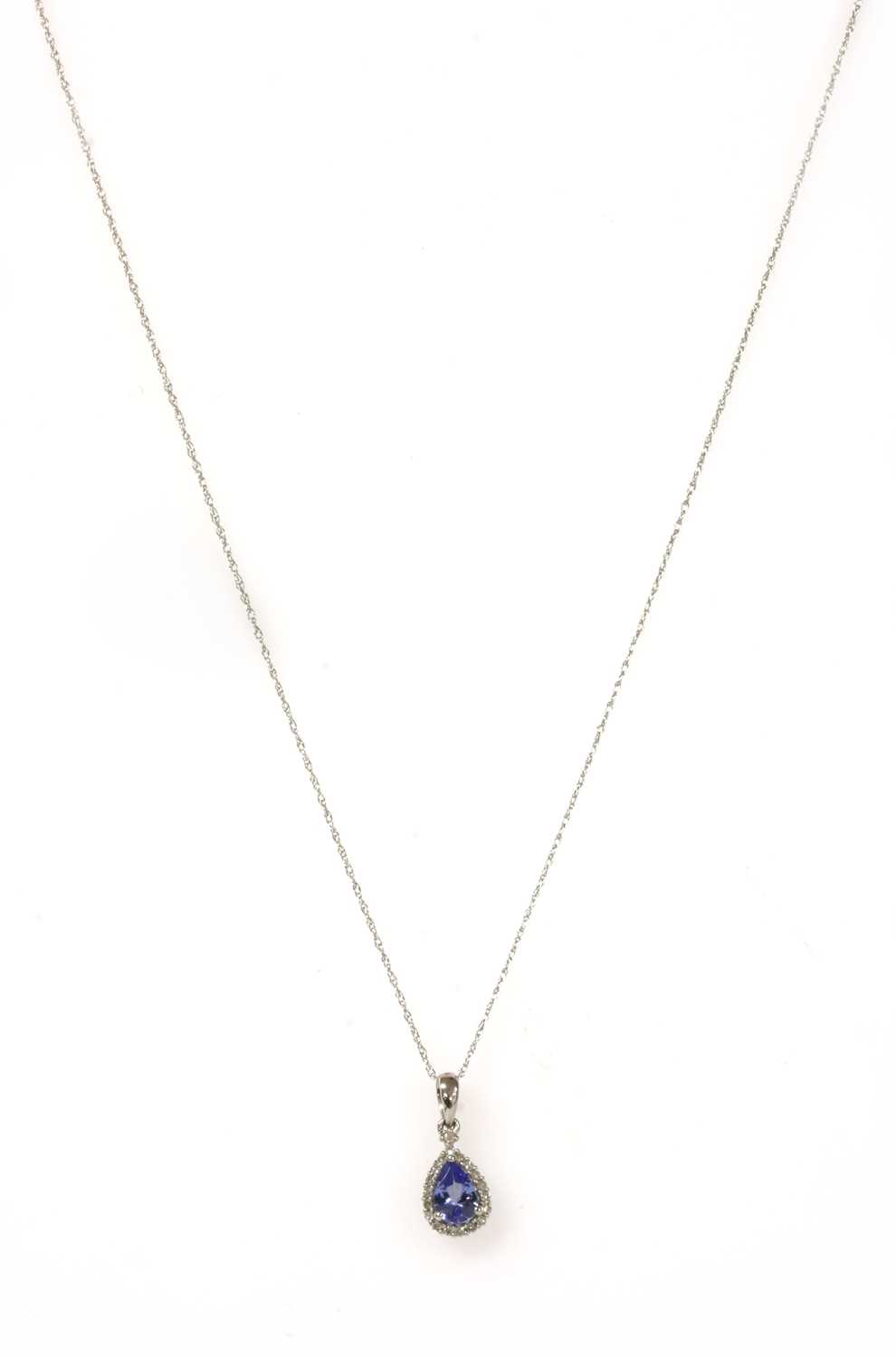 Lot 179 - A white gold tanzanite and diamond cluster pendant