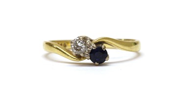 Lot 1288 - An 18ct gold two stone diamond and sapphire crossover ring