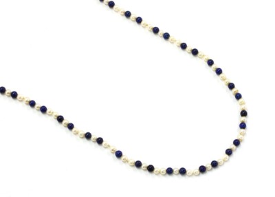 Lot 182 - A single row opera length uniform cultured freshwater pearl and lapis lazuli bead necklace