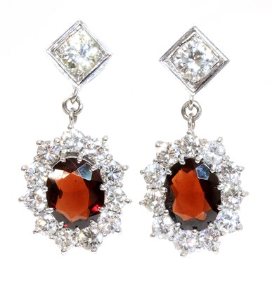 Lot 430 - A pair of 18ct white gold garnet and diamond cluster drop earrings