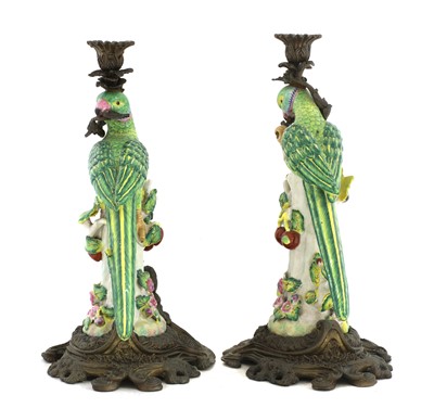 Lot 163 - A pair of gilt brass mounted pottery parrot candlesticks