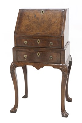 Lot 573 - A small George II-style walnut and feather-banded bureau on stand