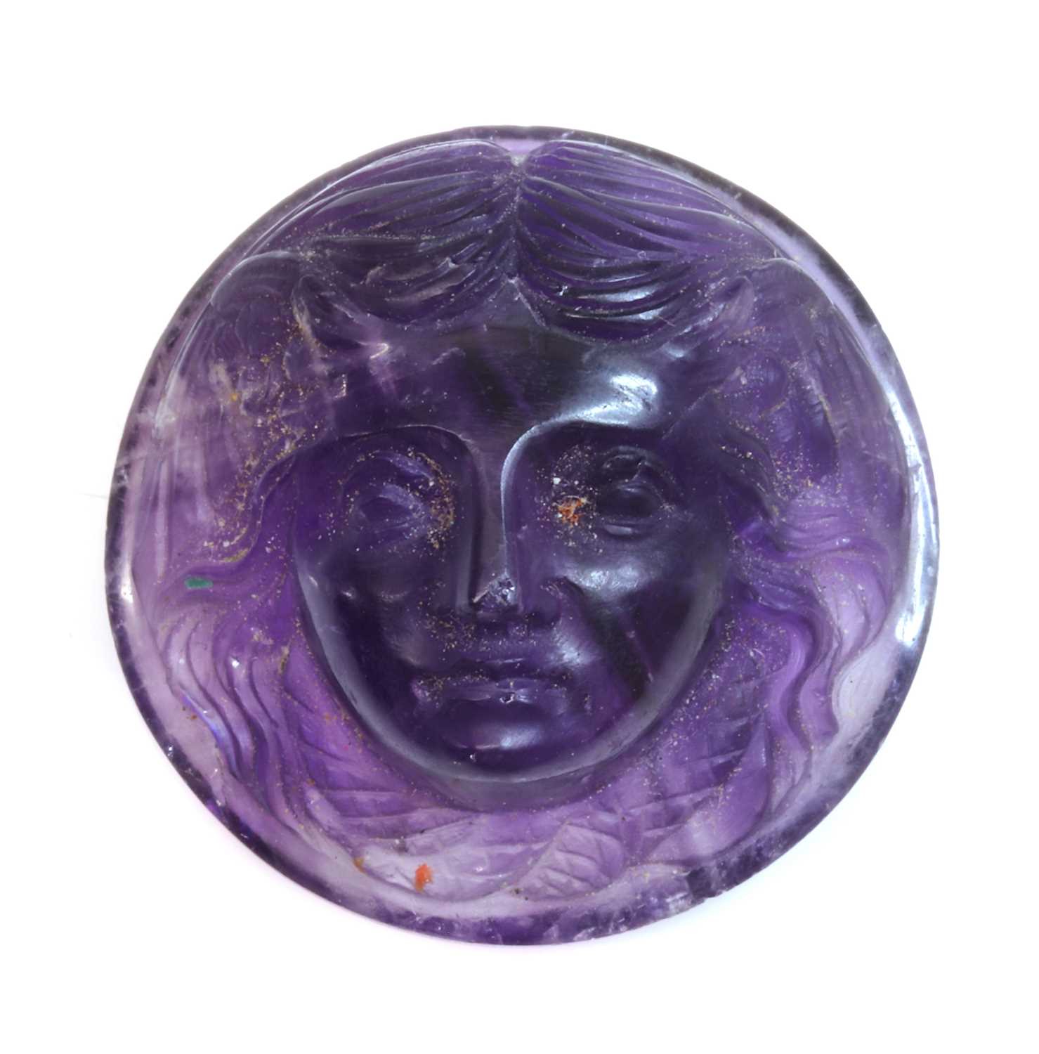 Lot 59 - An unmounted circular carved amethyst cameo