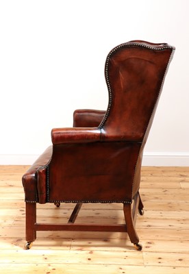 Lot 560 - A George III mahogany-framed leather wingback armchair