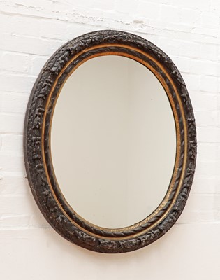 Lot 516 - A carved giltwood and ebonised oval wall mirror