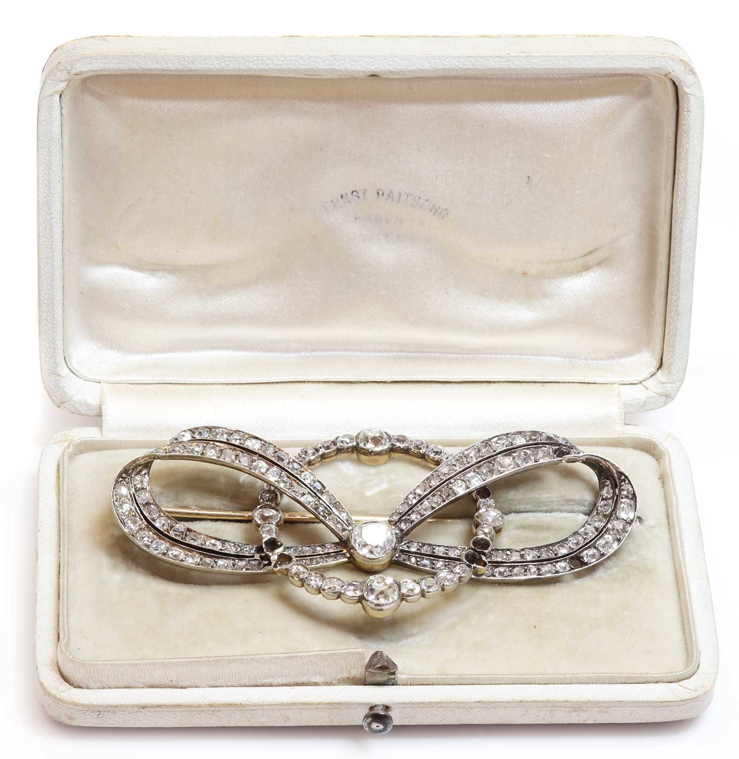 Lot 48 - A cased former Austro-Hungarian diamond set bow and hoop brooch, by Ernest Paltsho, Vienna, c.1900