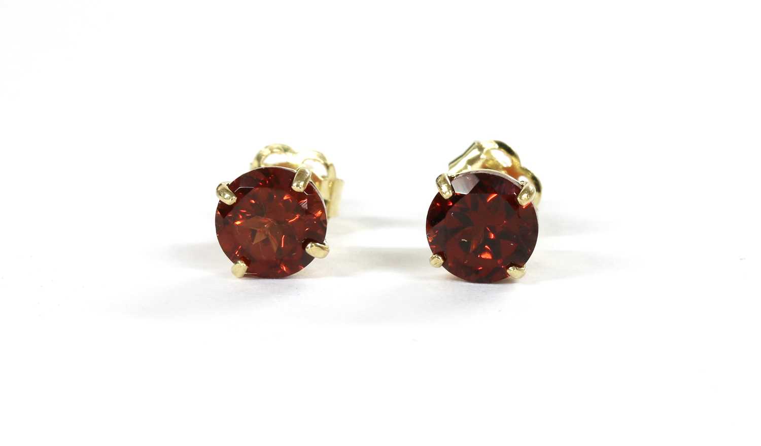 Lot 118 - A pair of gold single stone garnet stud earrings