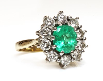 Lot 355 - An 18ct gold emerald and diamond cluster ring
