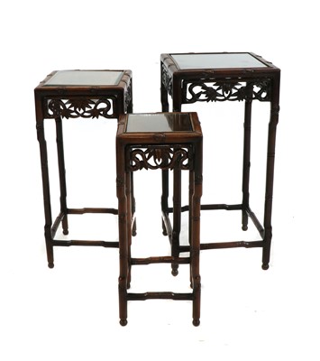 Lot 454 - A Chinese carved hardwood nest of three tables