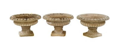 Lot 363 - A series of three composite stone garden urns