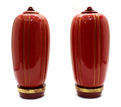 Lot 247 - A pair of red-glazed and gilt-heightened porcelain vases