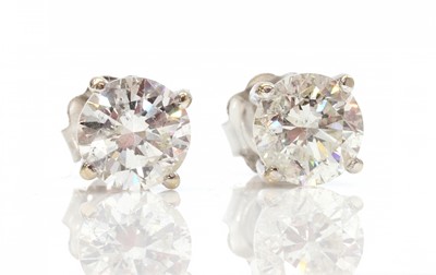 Lot 420 - A pair of 18ct white gold single stone fracture filled diamond stud earrings