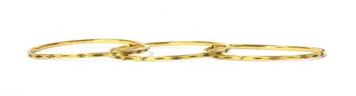 Lot 1160 - A set of three Indian high carat gold bangles