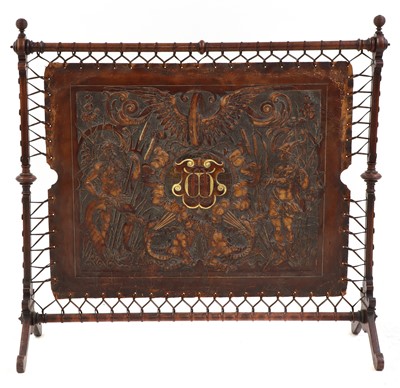 Lot 303 - An embossed leather and walnut fire screen
