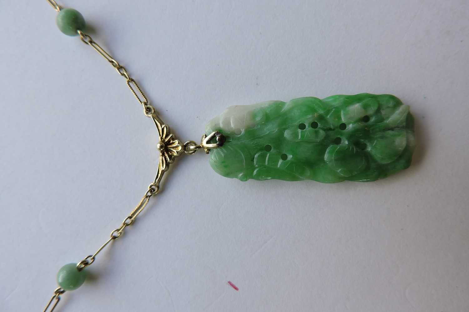 Lot 185 - An American carved jade plaque necklace,