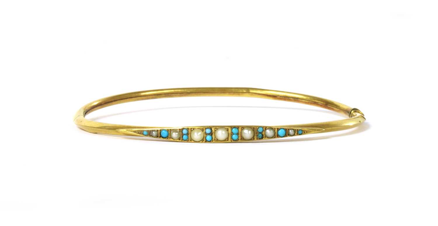 Lot 1036 - An Edwardian gold split pearl and turquoise oval bangle