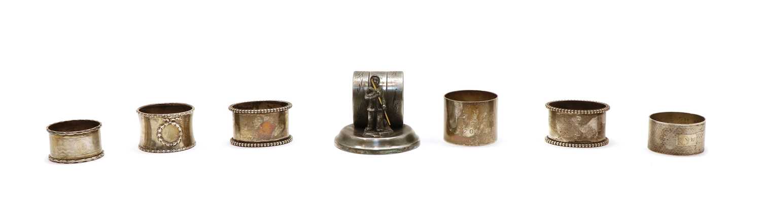 Lot 21 - Six silver napkin rings and a figural silver plated example