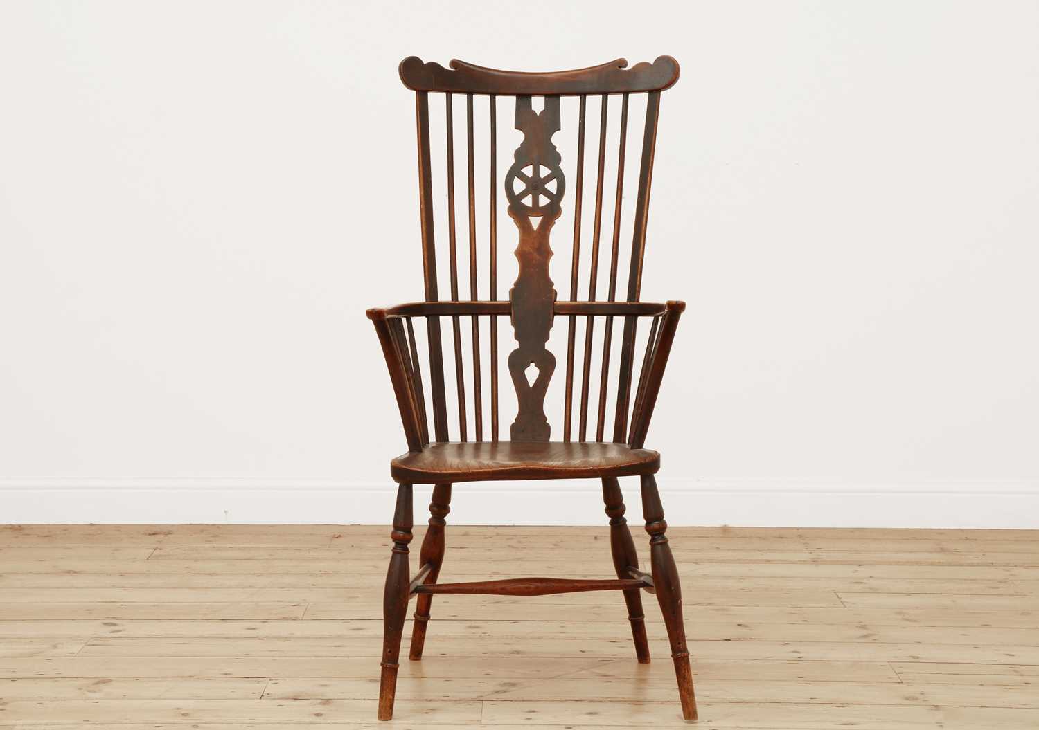 Lot 415 - A George III fruitwood and elm high comb back Windsor chair