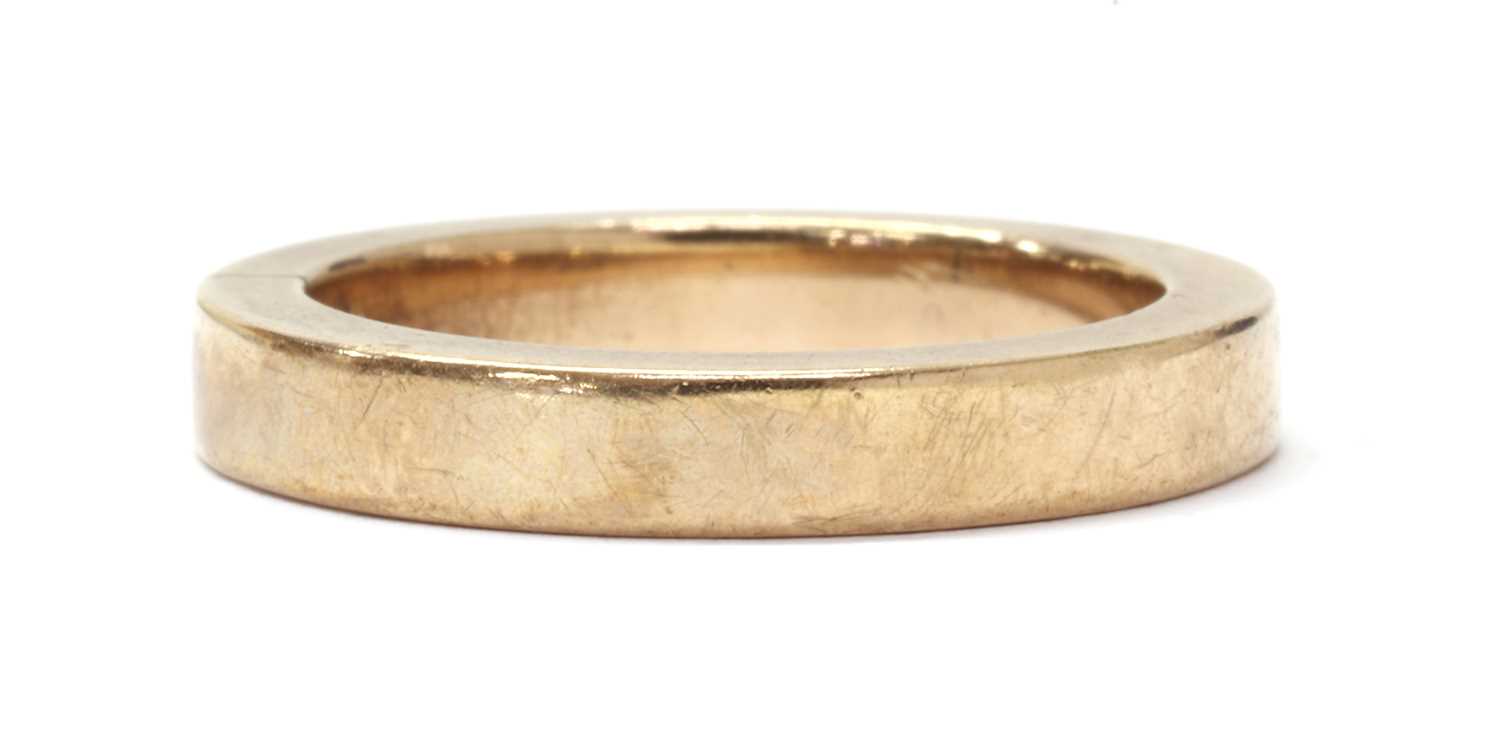 Lot 1075 - A gold flat section wedding ring