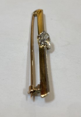 Lot 1165 - A gold and platinum single stone diamond bar brooch