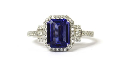 Lot 114 - An 18ct white gold tanzanite and diamond halo cluster ring