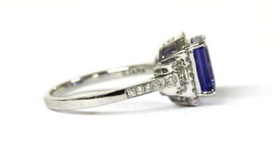 Lot 114 - An 18ct white gold tanzanite and diamond halo cluster ring