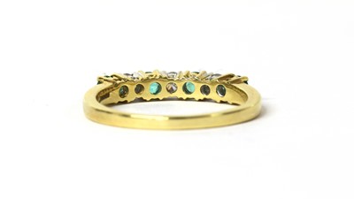 Lot 125 - An 18ct gold emerald and diamond half eternity ring