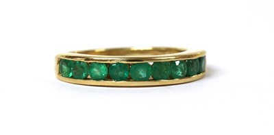 Lot 126 - An 18ct gold emerald half eternity ring