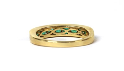 Lot 126 - An 18ct gold emerald half eternity ring