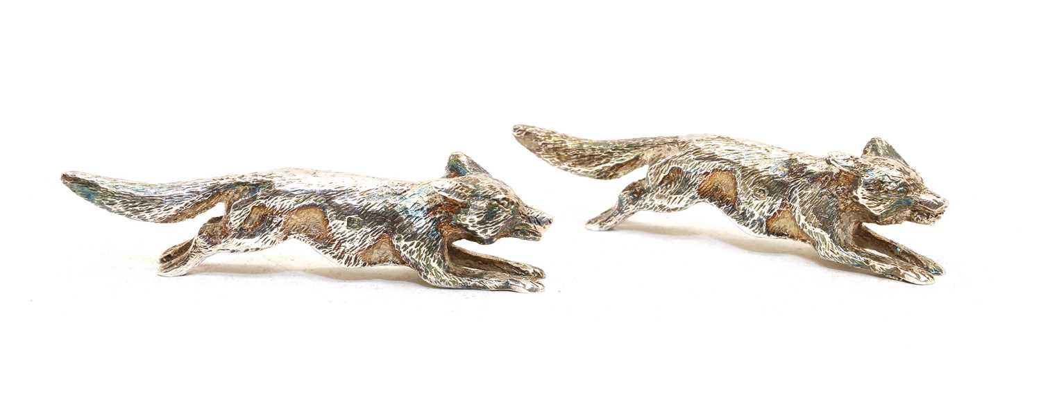 Lot 64 - Two silver running fox ornaments