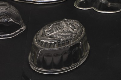 Lot 261 - A collection of seven glass and eight white pottery jelly moulds