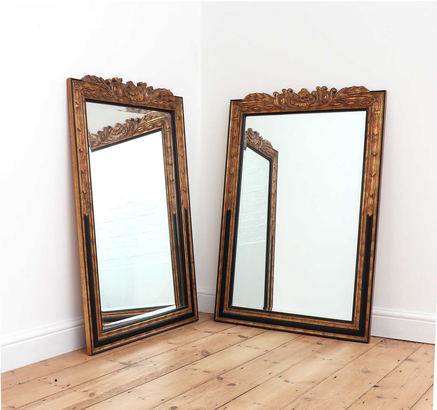 Lot 404 - A pair of ebonised and parcel-gilt mirrors