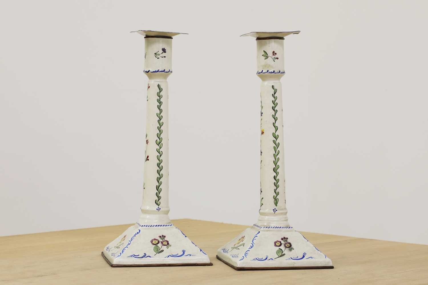 Lot 432 - A pair of enamel candlesticks