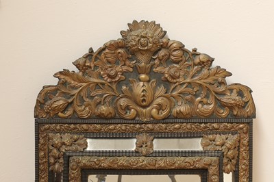 Lot 215 - An ebonised and embossed brass wall mirror