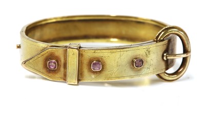 Lot 128 - A late Victorian gold jarretière style pink sapphire set bangle
