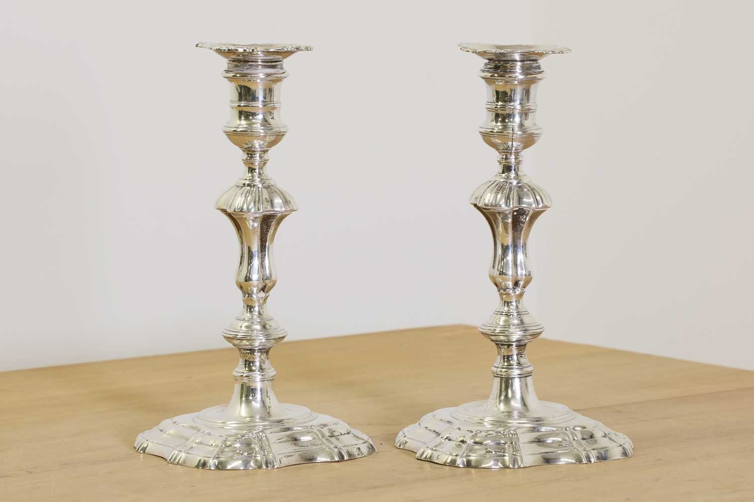 Lot 635 - Two George II cast silver candlesticks