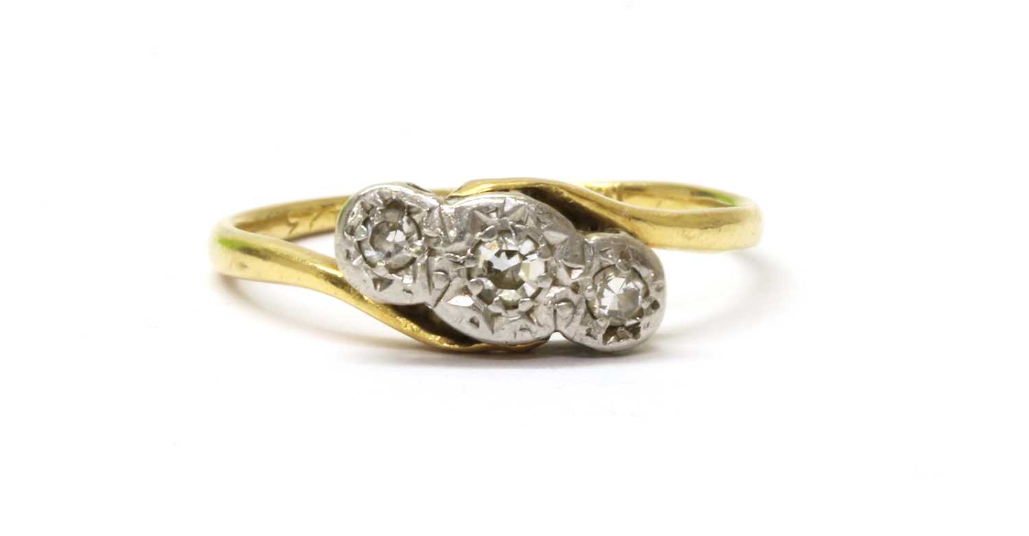 Lot 54 - A gold three stone diamond crossover ring