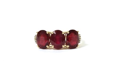 Lot 125 - A gold three stone fracture filled ruby ring