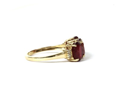 Lot 125 - A gold three stone fracture filled ruby ring