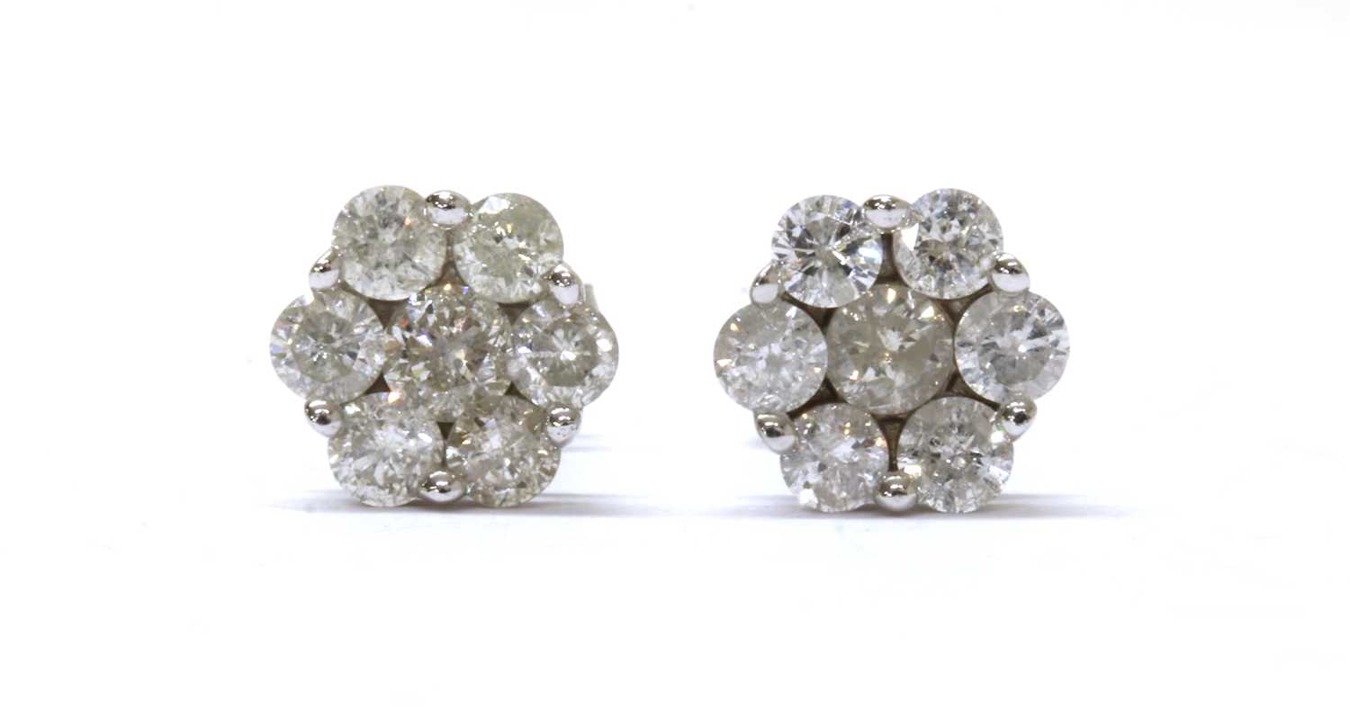 Lot 85 - A pair of white gold diamond daisy cluster earrings